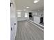 Bright living area with gray-toned flooring, recessed lighting, and open access to kitchen at 8795 Carrollton Ave, Indianapolis, IN 46240
