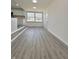 Sunlit living area features gray-toned flooring and open access to kitchen at 8795 Carrollton Ave, Indianapolis, IN 46240