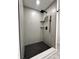 Sleek shower with black shower head, matte grey tile and black and white patterned floor at 8795 Carrollton Ave, Indianapolis, IN 46240