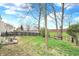 The backyard includes grass, mature trees, patio, fire pit and wood fence at 9243 Crossing Dr, Fishers, IN 46037