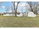The backyard features a tree, white storage sheds, and dog kennel at 9923 N 125 W, Fortville, IN 46040