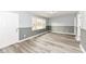 Bright living room featuring wood-look flooring, gray wainscoting, and neutral wall paint at 9923 N 125 W, Fortville, IN 46040