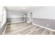 Bright living room featuring wood-look flooring, gray wainscoting, and neutral wall paint at 9923 N 125 W, Fortville, IN 46040