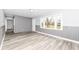 Bright living room featuring wood-look flooring, gray brick accent wall, and neutral wall paint at 9923 N 125 W, Fortville, IN 46040