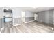 Bright living room featuring wood-look flooring, gray brick accent wall, and neutral wall paint at 9923 N 125 W, Fortville, IN 46040
