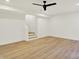 Open basement area with modern lighting, wood flooring, and stairs with temporary tread covers at 1024 Calvary St, Indianapolis, IN 46203