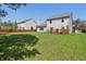 Large backyard with a red fence, mature trees, and a red deck at 10576 Greenway Dr, Fishers, IN 46037
