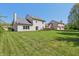 Expansive backyard with a lush lawn, mature trees, and a cozy deck at 10576 Greenway Dr, Fishers, IN 46037