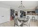 Bright dining area with modern chandelier, adjacent to the kitchen with stainless steel appliances and dark cabinetry at 10576 Greenway Dr, Fishers, IN 46037