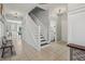 Hallway with stairs, tile flooring, white trim, and access to the laundry room at 10576 Greenway Dr, Fishers, IN 46037