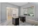 Bright home office with large window, dark wood desk, and an open doorway for seamless access at 10576 Greenway Dr, Fishers, IN 46037