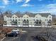View of condo buildings with multiple stories, garage access, small balconies, and ample parking at 1074 Reserve Way, Indianapolis, IN 46220