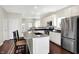 Open kitchen featuring white cabinets, stainless appliances, granite countertops, and a center island with seating at 1074 Reserve Way, Indianapolis, IN 46220