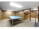 Spacious basement with wood paneling, carpeted floors, and a blue ping pong table at 10817 Lakeview Dr, Carmel, IN 46033