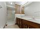 Bathroom featuring wallpaper, double sinks, and glass enclosed shower at 10817 Lakeview Dr, Carmel, IN 46033
