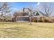 Back view of a brick home with a screened-in porch and expansive backyard with mature trees at 10817 Lakeview Dr, Carmel, IN 46033
