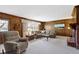 Cozy living room features wood paneling, a fireplace, and ample seating at 10817 Lakeview Dr, Carmel, IN 46033