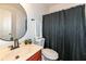 Compact bathroom with a simple vanity, toilet, and a shower with a black patterned curtain at 1120 Oak Hill Ln, Cicero, IN 46034