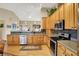 Well-lit kitchen boasts stainless steel appliances, wooden cabinetry, and an open design at 129 W Clear Lake Ln, Westfield, IN 46074