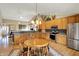 Bright eat-in kitchen featuring wooden cabinets, stainless steel appliances, and a stylish light fixture at 129 W Clear Lake Ln, Westfield, IN 46074