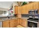 Close-up of a kitchen with wood cabinets, granite countertops, and stainless steel appliances at 129 W Clear Lake Ln, Westfield, IN 46074
