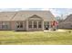 Spacious backyard featuring a brick home exterior, patio set, grill, and a well-kept lawn at 1382 Redstone Dr, Avon, IN 46123