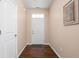 Hallway with wood-look flooring, neutral walls, leading to a white front door with an accent rug at 1382 Redstone Dr, Avon, IN 46123