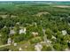 An aerial perspective highlights a neighborhood with houses nestled among dense trees creating a secluded feel with winding roads at 1409 S Harmony Trl, Greenfield, IN 46140