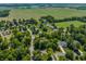 A picturesque aerial shot showcasing a neighborhood with homes and lush greenery meeting expansive agricultural fields at 1409 S Harmony Trl, Greenfield, IN 46140