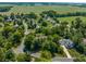 An aerial view of a neighborhood nestled among trees and lush farmland, offering a serene and picturesque setting at 1409 S Harmony Trl, Greenfield, IN 46140