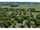 An aerial view reveals the neighborhood layout where homes blend into the tree cover with a tranquil community feel at 1409 S Harmony Trl, Greenfield, IN 46140