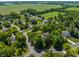 An aerial view captures the neighborhood's layout, blending homes with trees and the open expanse of a nearby field at 1409 S Harmony Trl, Greenfield, IN 46140