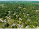 Aerial shot displays a neighborhood nestled among dense trees, creating a peaceful and nature-filled environment at 1409 S Harmony Trl, Greenfield, IN 46140