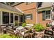 View of the outdoor patio area with fire pit, brick exterior, and green shrubs at 1409 S Harmony Trl, Greenfield, IN 46140