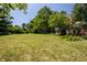 Picture of spacious backyard featuring a lush lawn with beautiful trees and green foliage at 1409 S Harmony Trl, Greenfield, IN 46140