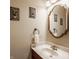 Cozy bathroom features an oval framed mirror, framed art, and marble countertop sink at 1409 S Harmony Trl, Greenfield, IN 46140
