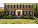 Close up of brick home featuring a bright red front door and manicured bushes at 1409 S Harmony Trl, Greenfield, IN 46140