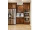 This kitchen features stainless steel appliances, wooden cabinetry, granite countertops, and modern tile backsplash at 1409 S Harmony Trl, Greenfield, IN 46140