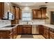 Well-lit kitchen with wooden cabinets, granite countertops, and stainless steel appliances offers both style and functionality at 1409 S Harmony Trl, Greenfield, IN 46140