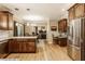 Open-concept kitchen with stainless steel appliances, granite countertops, and hardwood floors transitions to dining and living spaces at 1409 S Harmony Trl, Greenfield, IN 46140