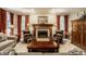 Cozy living room with a fireplace, leather chairs, and matching side tables and lamps at 1409 S Harmony Trl, Greenfield, IN 46140