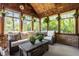 Cozy sunroom with wicker furniture, wood paneled ceiling, and lots of natural light from the large windows at 1409 S Harmony Trl, Greenfield, IN 46140