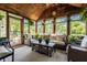Bright sunroom featuring vaulted wood ceilings, comfortable wicker furniture, and views of the lush garden at 1409 S Harmony Trl, Greenfield, IN 46140