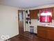 This kitchen showcases wooden cabinets, a stainless steel trash can and a window with red curtains at 1507 Hannibal St, Noblesville, IN 46060