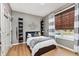 Cozy bedroom featuring wood floors, wall decor, and a window letting in natural light at 15104 Midland Ln, Noblesville, IN 46062