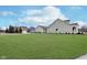 View of a well maintained lawn and the side of a light green single Gathering home at 15104 Midland Ln, Noblesville, IN 46062