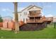 Expansive backyard featuring a two-story deck, a lush green lawn, and mature landscaping offers privacy and outdoor living at 15506 Slateford Rd, Noblesville, IN 46062