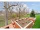 This view features raised planters on the deck, ideal for gardening with an outdoor area and tree backdrop at 15506 Slateford Rd, Noblesville, IN 46062