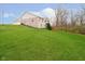 A sprawling backyard on a gentle slope with lush green grass surrounding the home and deck is shown at 15506 Slateford Rd, Noblesville, IN 46062
