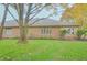 Expansive backyard with lush green grass and mature trees behind the beautiful brick home at 1738 Pathway S Dr, Greenwood, IN 46143